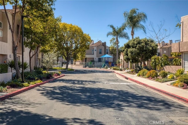 view of road with a residential view, curbs, and sidewalks