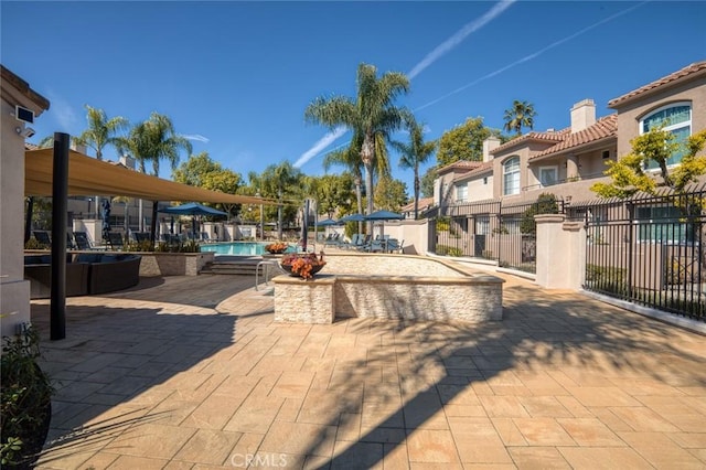 surrounding community with a swimming pool, a residential view, a patio area, and fence