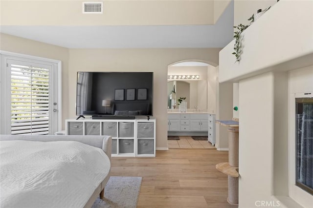 bedroom featuring visible vents, ensuite bathroom, and light wood-type flooring