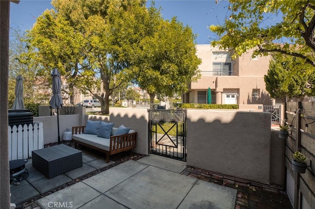 view of patio with fence, outdoor lounge area, and a gate