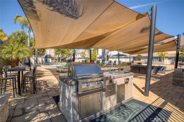 view of patio / terrace with grilling area, an outdoor kitchen, and fence