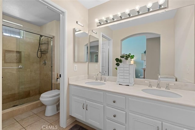 bathroom with a shower stall, toilet, and a sink