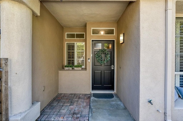 view of exterior entry with stucco siding