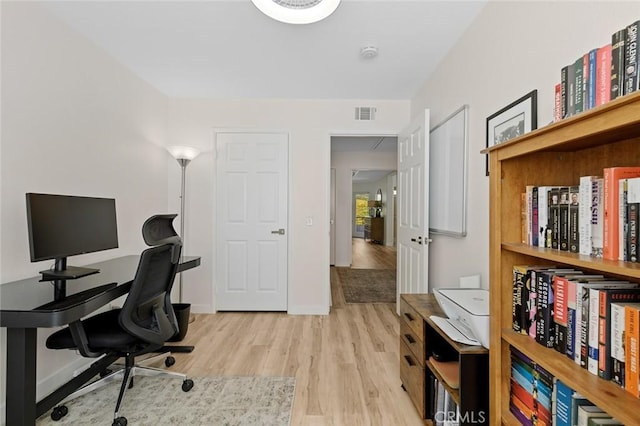 office area featuring light wood-style flooring, baseboards, and visible vents