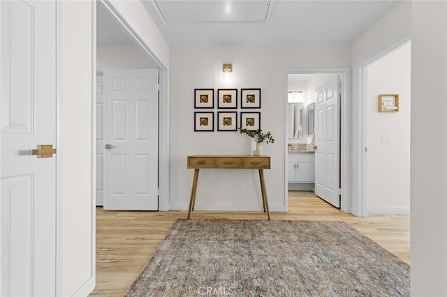 hall with baseboards and wood finished floors