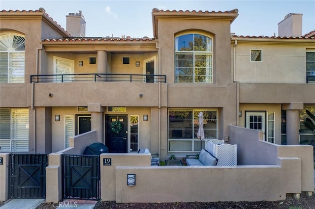 exterior space with outdoor lounge area, stucco siding, and a chimney