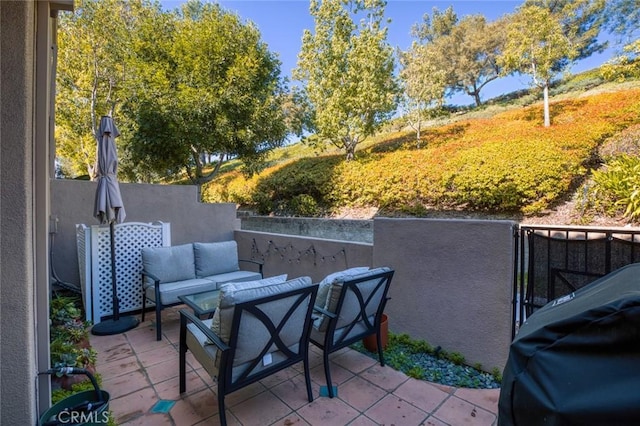 view of patio / terrace featuring a grill, fence, and an outdoor hangout area