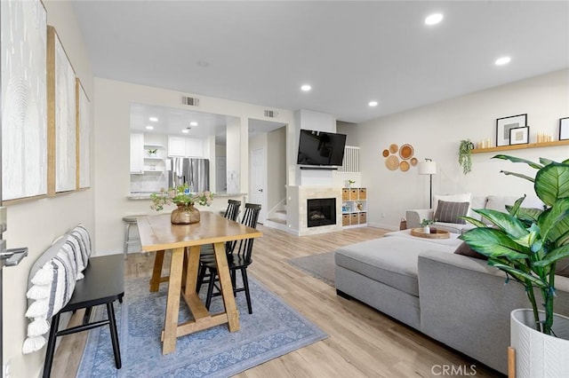 living area featuring recessed lighting, visible vents, light wood-style floors, and a fireplace