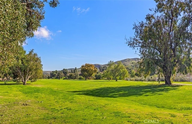 view of home's community with a mountain view and a lawn