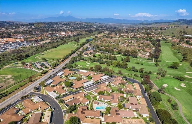 drone / aerial view featuring view of golf course, a mountain view, and a residential view