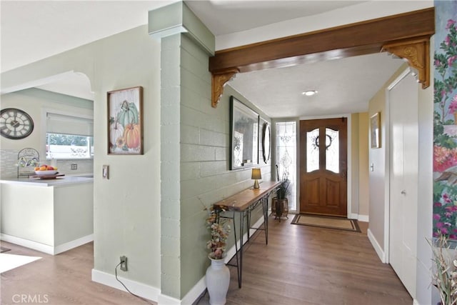 foyer entrance with wood finished floors and baseboards