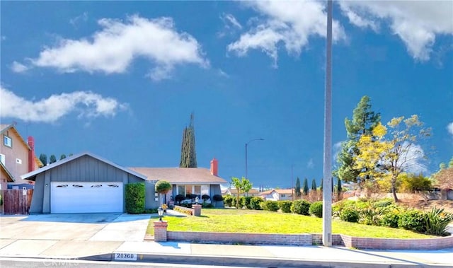 view of front of house with a front lawn, concrete driveway, and a garage