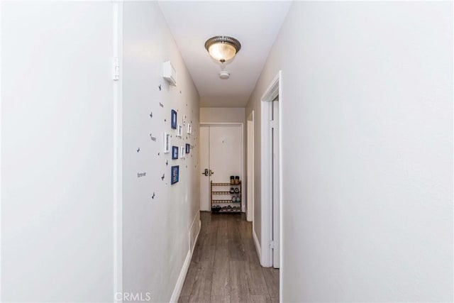 hall featuring baseboards and light wood-style floors