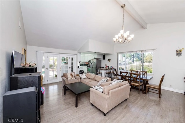 living room featuring beam ceiling, a chandelier, french doors, and light wood-type flooring