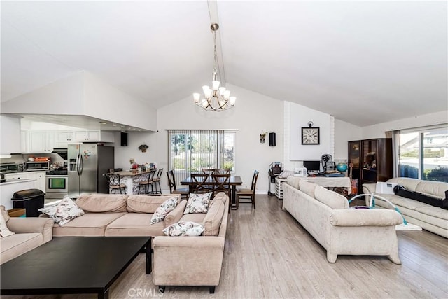 living area with an inviting chandelier, vaulted ceiling, and light wood-style floors