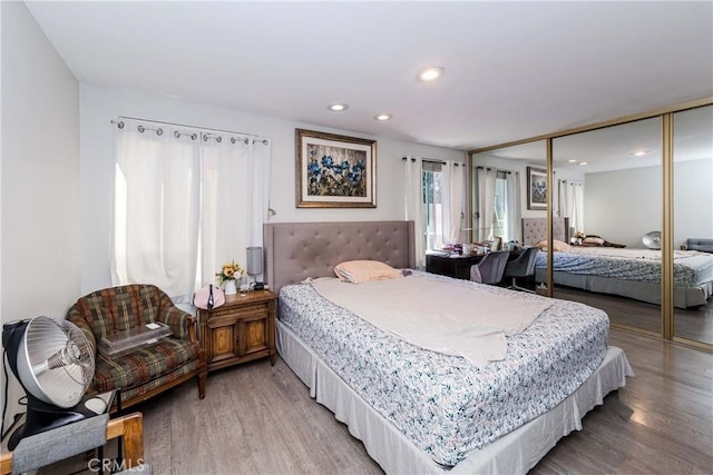 bedroom with a closet, recessed lighting, and wood finished floors