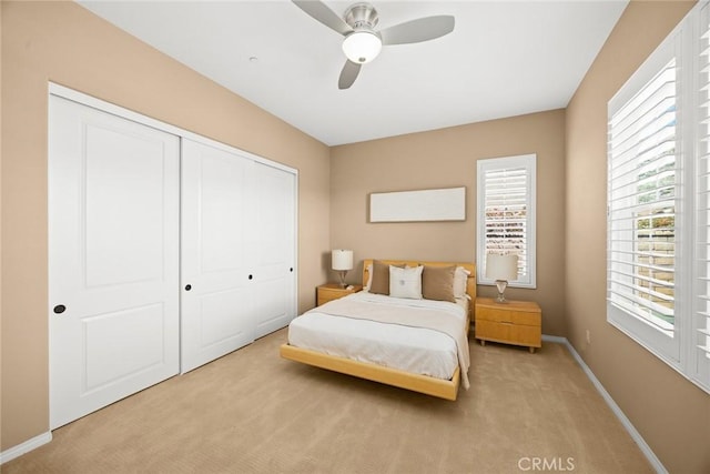 carpeted bedroom with baseboards, a closet, and ceiling fan