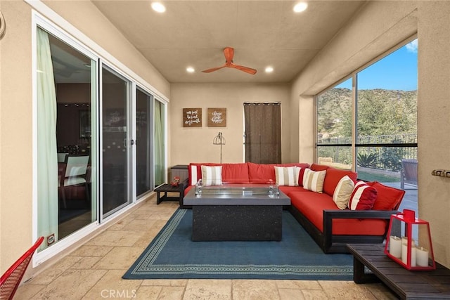 sunroom / solarium featuring a ceiling fan