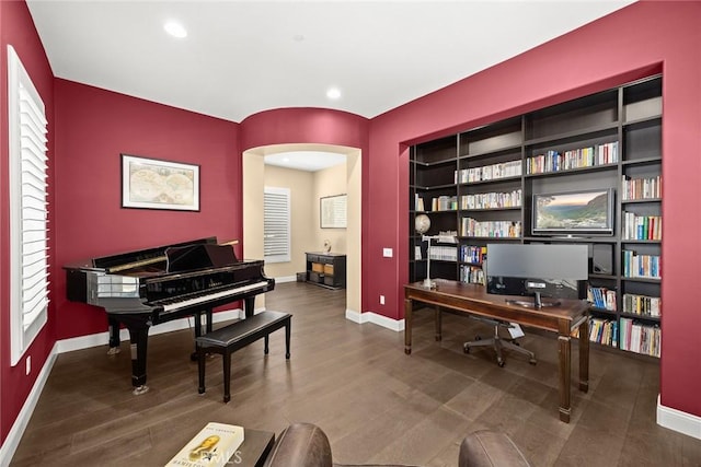 office with arched walkways, recessed lighting, baseboards, and wood finished floors