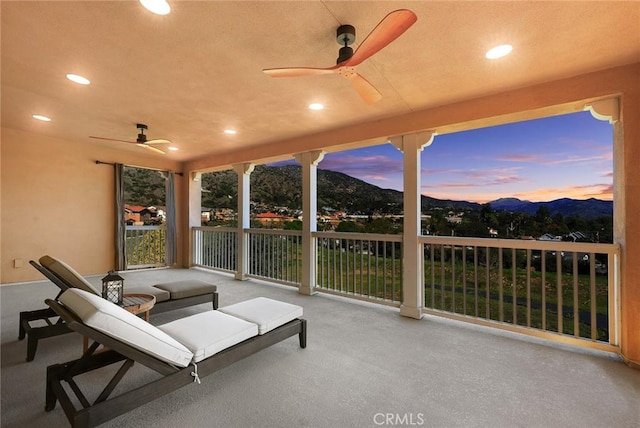 patio terrace at dusk with a mountain view and ceiling fan