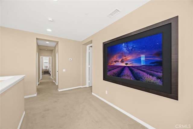 interior space with visible vents, light carpet, and baseboards