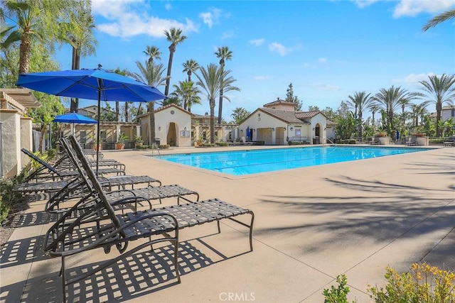 community pool featuring a patio and fence