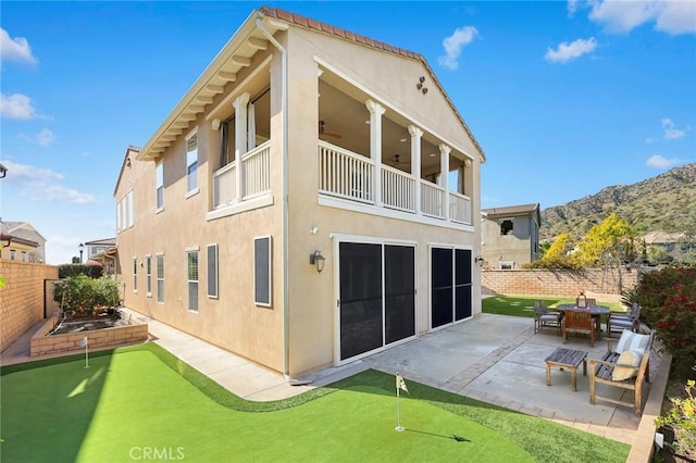 back of property featuring a patio, a balcony, a fenced backyard, stucco siding, and ceiling fan