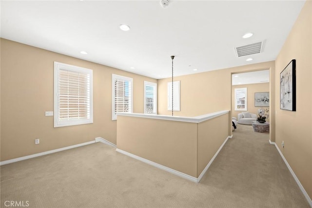 hall with recessed lighting, visible vents, light colored carpet, and baseboards