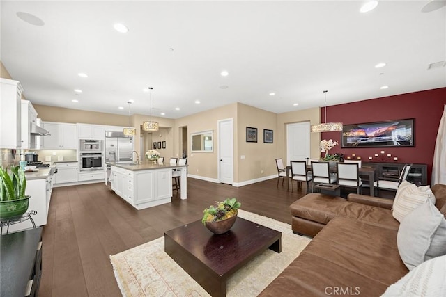 living room with recessed lighting, baseboards, and dark wood-style flooring