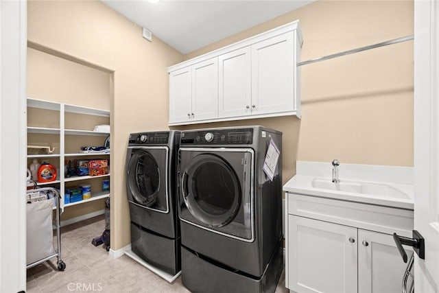 laundry room featuring a sink, cabinet space, washing machine and dryer, and light tile patterned floors