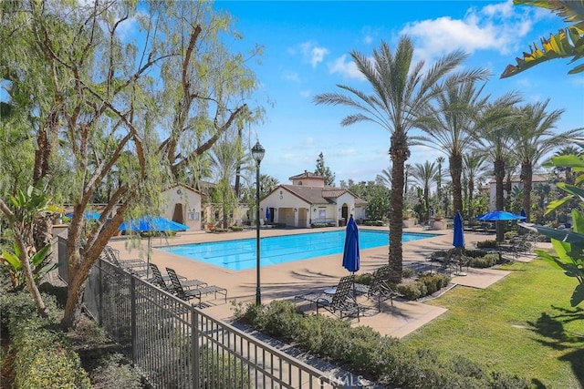 pool featuring a patio area, fence, and a lawn