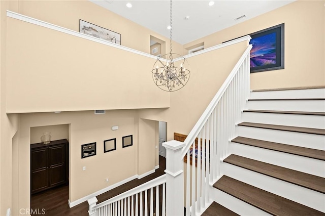 staircase with recessed lighting, visible vents, an inviting chandelier, and wood finished floors