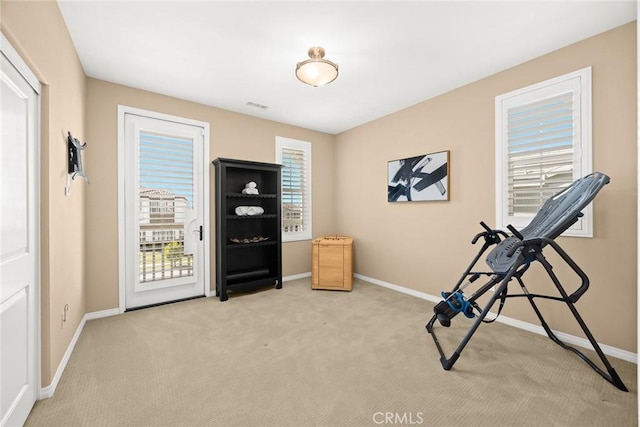 workout room featuring visible vents, baseboards, and light colored carpet