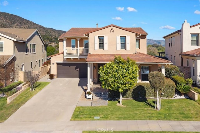 view of front facade featuring a tiled roof, stucco siding, a mountain view, and concrete driveway