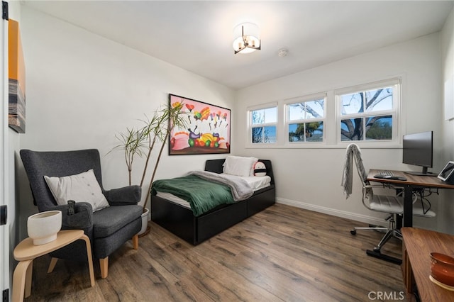 bedroom with wood finished floors and baseboards