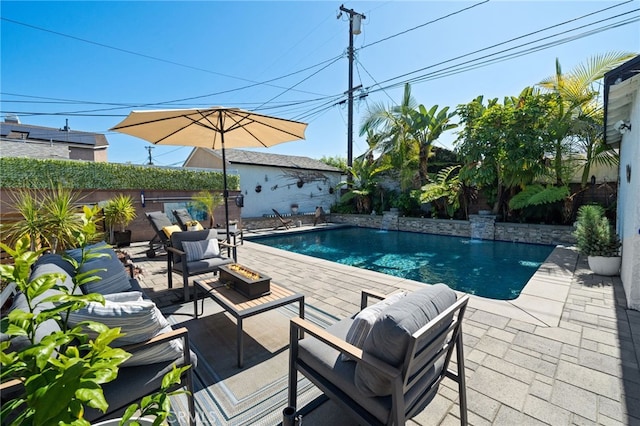 view of pool with a patio area, a fenced in pool, an outdoor living space with a fire pit, and a fenced backyard