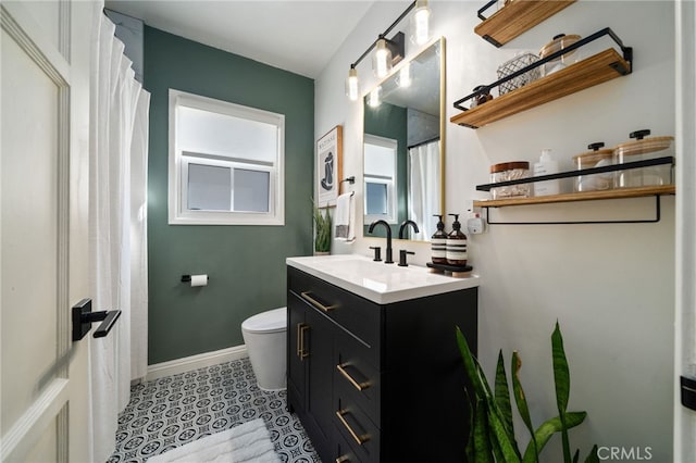 full bath featuring baseboards, toilet, vanity, and tile patterned flooring