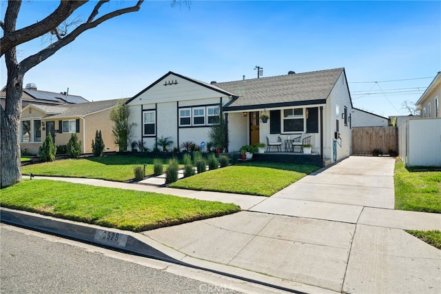 view of front of home featuring stucco siding, a porch, a front lawn, and fence