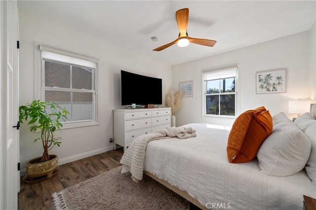 bedroom with a ceiling fan, baseboards, and wood finished floors