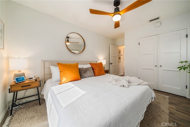 bedroom with a closet, visible vents, a ceiling fan, and wood finished floors