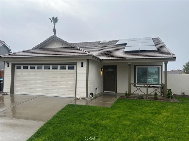 ranch-style house with solar panels, concrete driveway, a front yard, and a tile roof