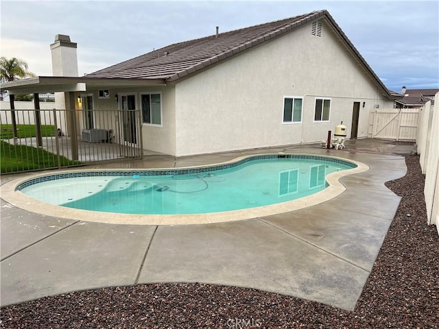 view of swimming pool featuring a gate, a fenced in pool, a patio, and fence