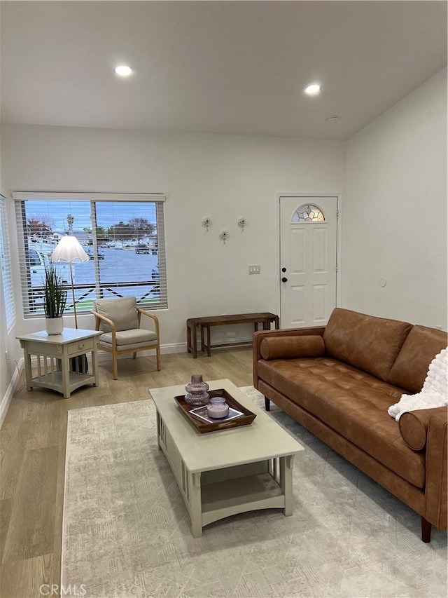 living area with recessed lighting, light wood-type flooring, and baseboards