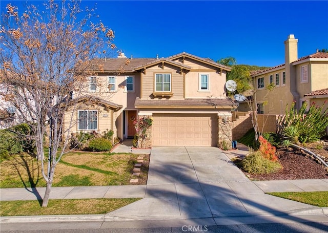 traditional-style home featuring a garage, stone siding, driveway, and fence