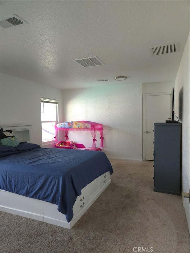 bedroom with visible vents, a textured ceiling, and carpet