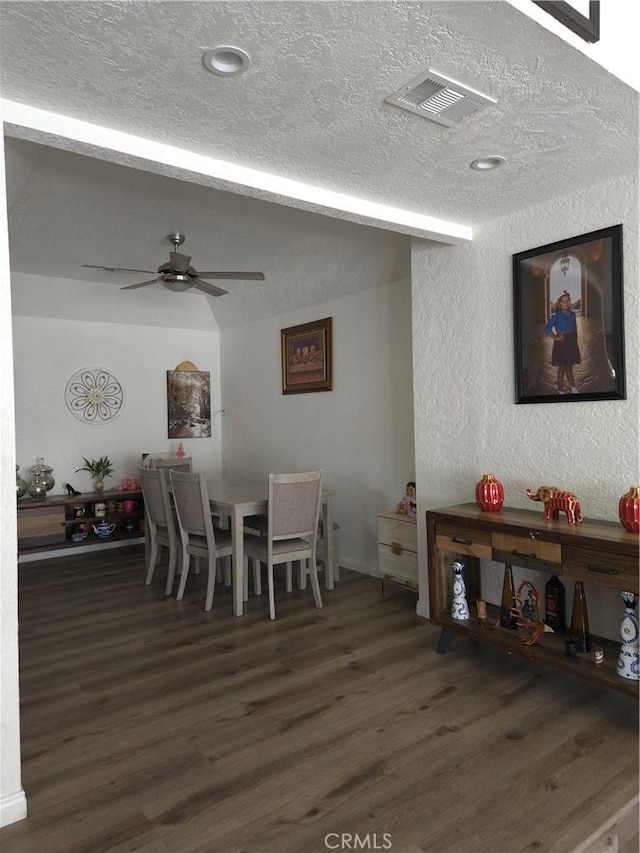 dining room featuring visible vents, ceiling fan, beam ceiling, wood finished floors, and a textured ceiling