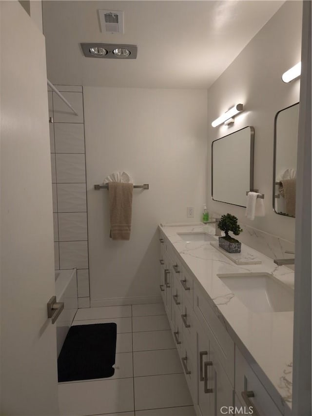 full bathroom with tile patterned flooring, double vanity, visible vents, and a sink