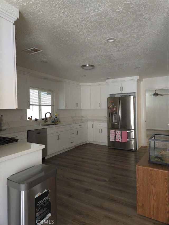 kitchen with dark wood-style flooring, white cabinets, dishwasher, and stainless steel fridge with ice dispenser