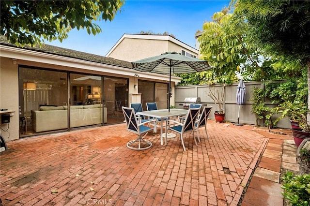 view of patio / terrace with grilling area, outdoor dining area, and fence