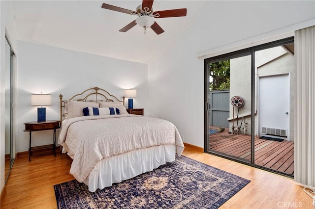 bedroom featuring wood finished floors, baseboards, visible vents, lofted ceiling, and ceiling fan